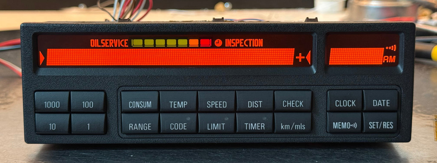 Car dashboard display with digital readout and buttons on a wooden surface