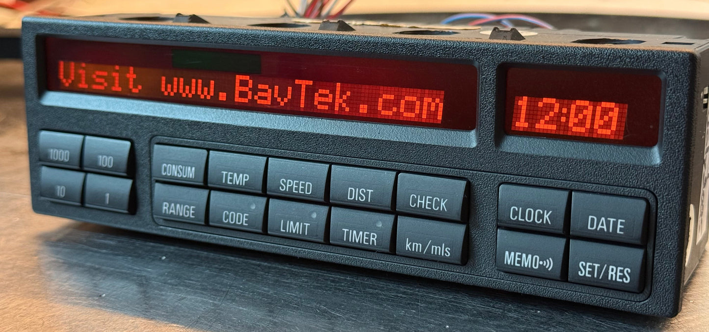 Vintage digital display device with red text and buttons on a wooden surface