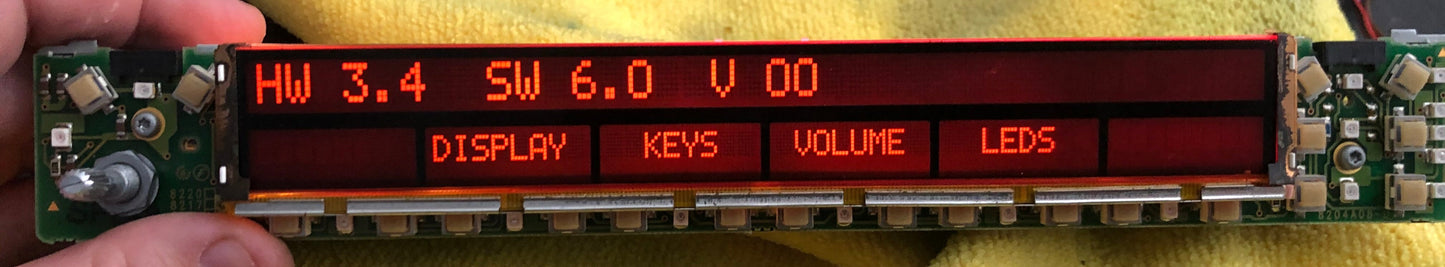 Electronic component with digital display held by a hand on a yellow cloth