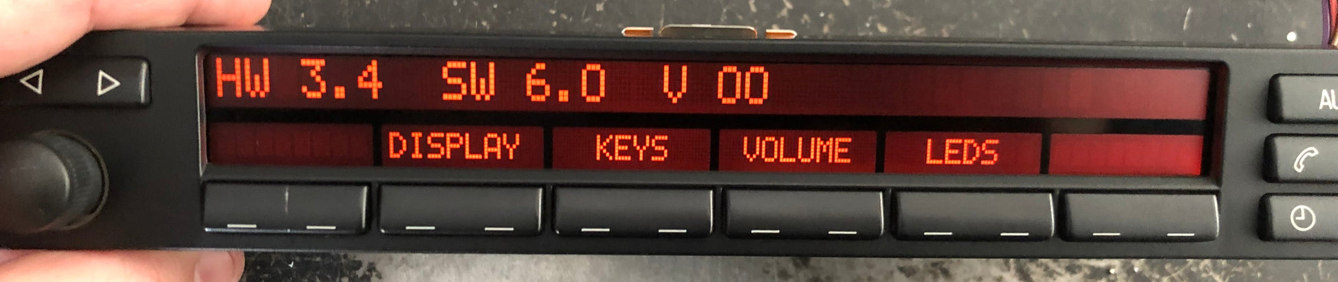 Digital display panel held by a hand on a dark surface
