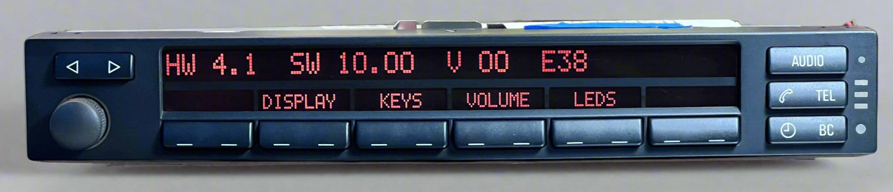 Car stereo with digital display and control buttons on a reflective surface