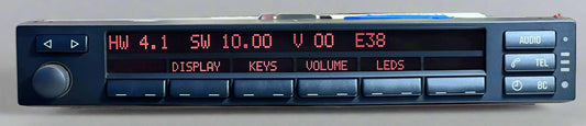 Car stereo with digital display and control buttons on a reflective surface