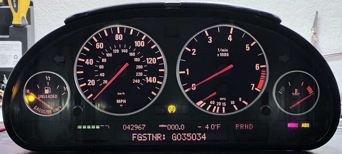 Car dashboard with illuminated gauges on a gray surface